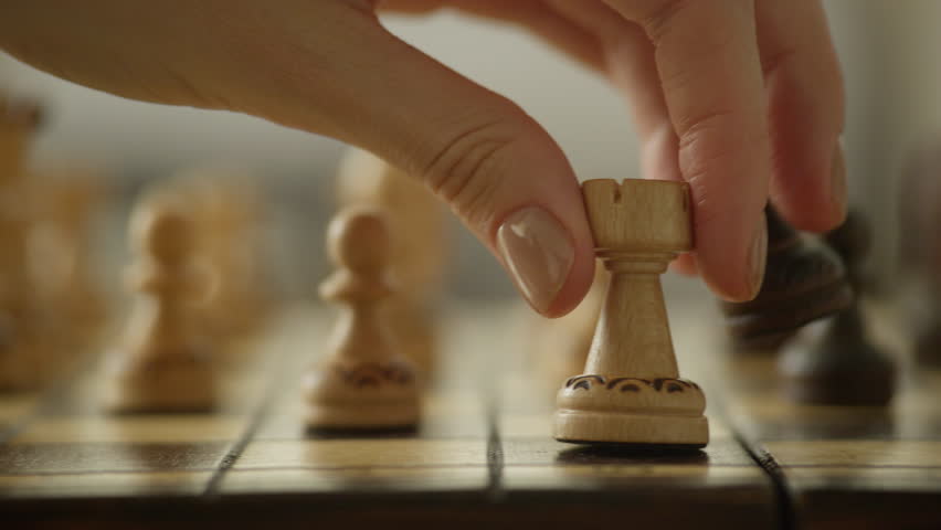 Hand Moving Chess Piece on Board