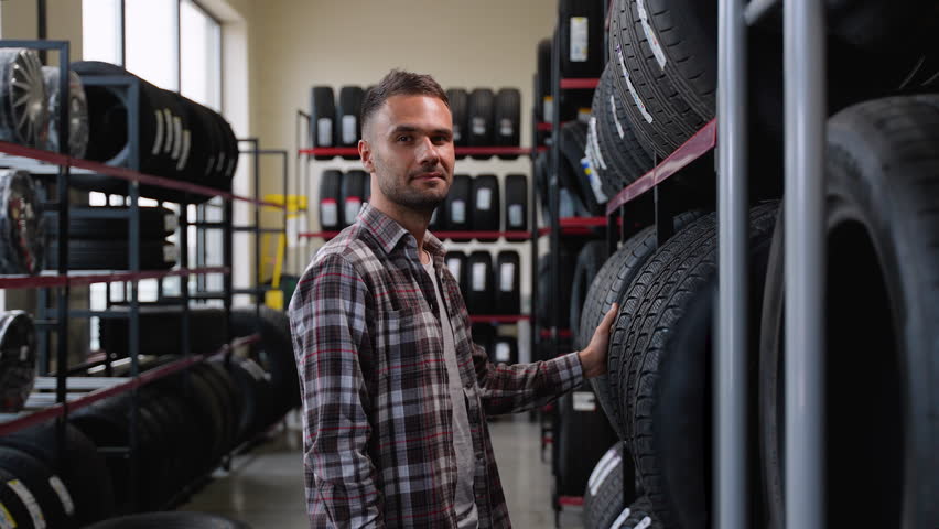 Satisfied customer in a tire store. Concept of choosing tires for the season