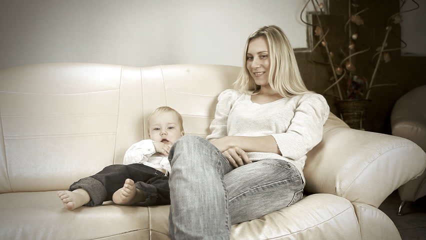 Mother with son on sofa watch TV