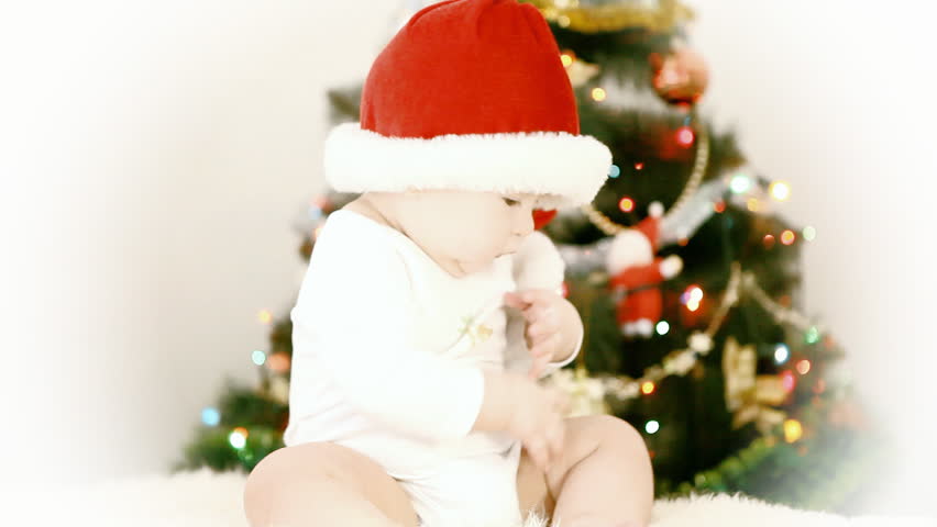 Baby in Christmas hat on the new year background