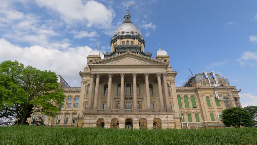 Views of the front facade of the Illinois State Capitol Building. Scaffolding and construction equipment with ongoing construction at the building.