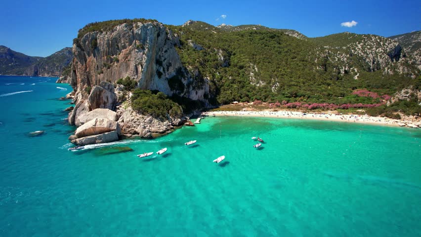 Best and most beautiful beaches of Sardegna island (Italy) - Cala Luna in gulf of Orosei . Aerial panoramic drone view of white sandy beach , caves and turquoise sea. high angle 4khd video