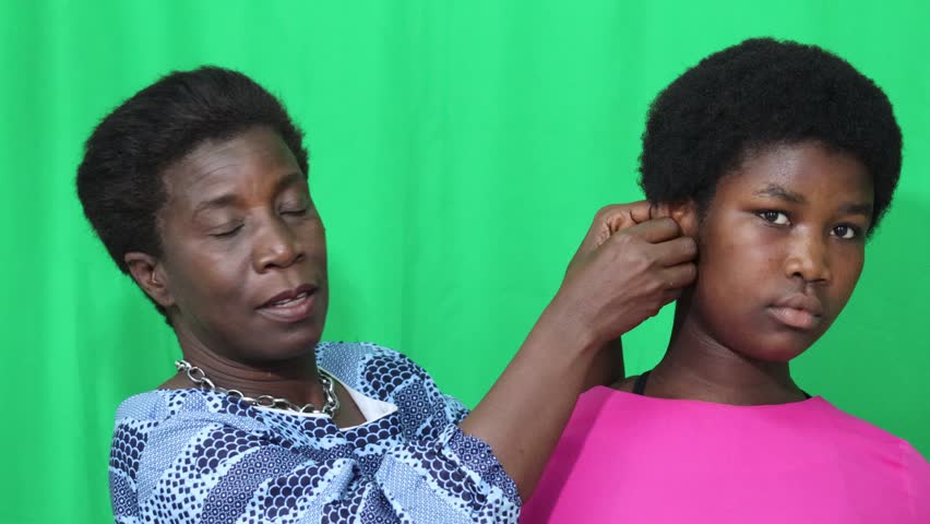 An adult woman caring for her daughter while wearing her earrings.