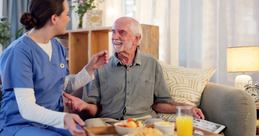 Caregiver, home and assistance with breakfast in elderly care for living room service, meal or food. Happy nurse serving lunch or dinner to senior man patient for support, trust or morning nutrition