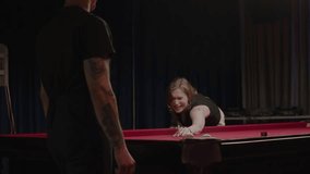 Couple is playing pool, and the woman misses a shot and laughs at herself for making a mistake. - Powered by Shutterstock - Get 15% off with code: PIKWIZARD15