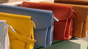 Vibrant Leather Handbags for Young Women: Trendy and Affordable Fashion Accessories | Colorful Purse Collection on Glass Display in Chic Boutique Store | Stylish Options for Modern Fashionistas - Powered by Shutterstock - Get 15% off with code: PIKWIZARD15