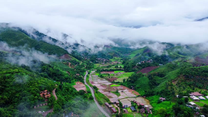 Aerial view of the beautiful Sapan village scenery, a small village in the middle of a valley surrounded by nature during the rainy season at Nan Province, Thailand.