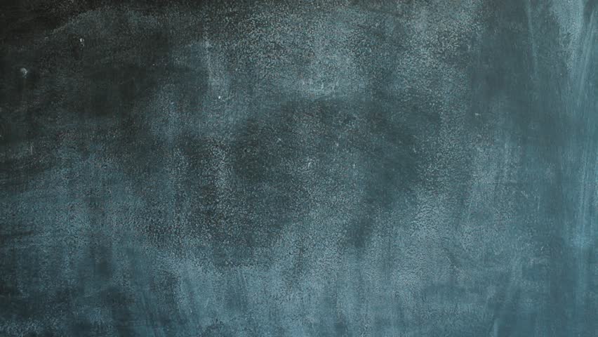 A male teacher writing E=mc2 theory of relativity physics formula on blackboard