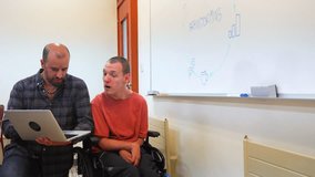 Brainstorming meeting of a man with disability and a colleague in the university - Powered by Shutterstock - Get 15% off with code: PIKWIZARD15