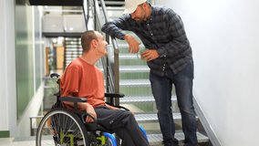Man assisting a coworker with disability walking and pushing his wheelchair along a corridor - Powered by Shutterstock - Get 15% off with code: PIKWIZARD15