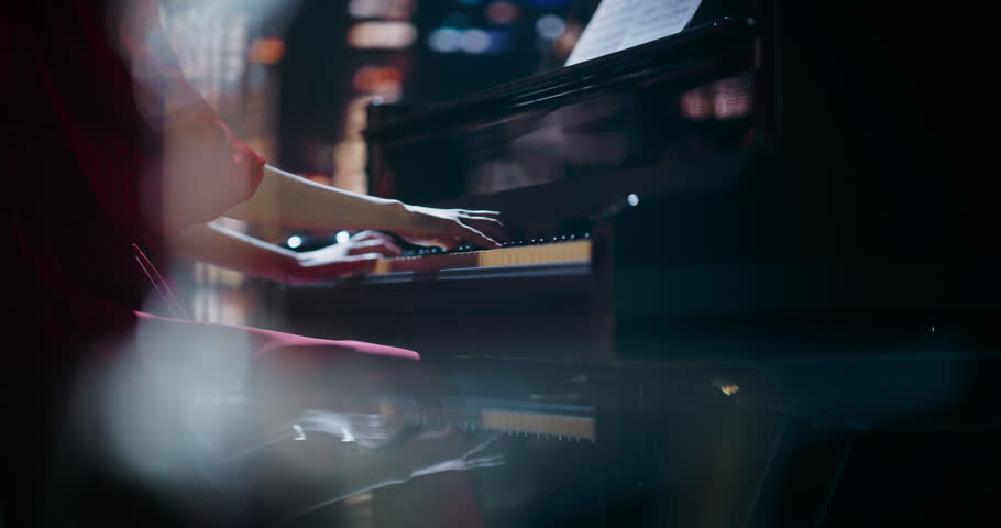 Close Up on Pianist Hands Playing a Mesmerizing Jazz Melody on a Black Grand Piano. Anonymous Artist is Focused on Creating Beautiful Instrumental Sonata as She Plays on Stage for the Audience