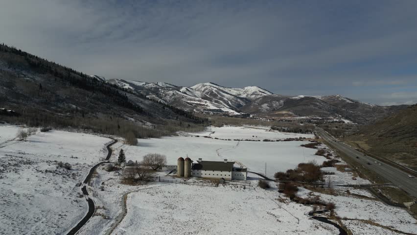 An aerial view of the McPolin Barn and McPolin Farm Nature Trail in the winter on a sunny day in Park City, Utah, United States