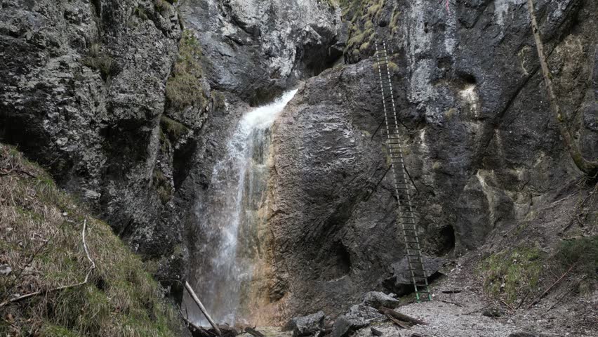 Aerial footage of tall waterfall on the rocky cliff, Slovak Paradise park, 4k