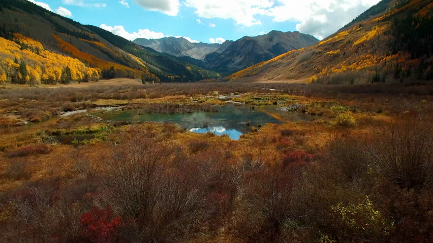 Aerial: Scenic Shot Of Aspen Trees On Rock Formations, Drone Flying Forward Over Lake During Autumn Season