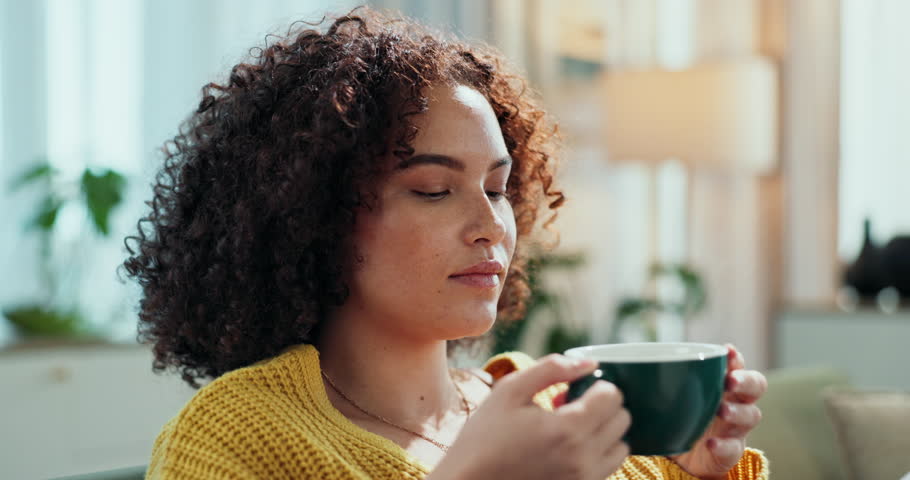 Woman, drinking tea and peace in home on weekend, happiness and hot beverage for self care. Female person, coffee and aroma for comfort in living room, relax and espresso for satisfaction on sofa