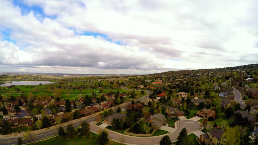 Aerial Panning Scenic Shot Of Roofed Houses On Green Landscape Under Cloudy Sky - Colorado Springs, Colorado