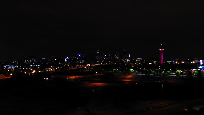 Aerial: Drone Upward Illuminated Observation Tower In Amusement Park In City Against Clear Sky At Night - Denver, Colorado