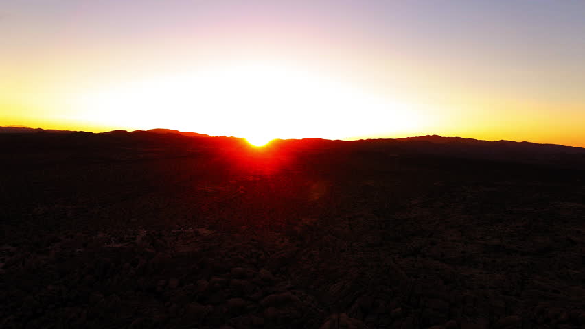 Aerial Panning Scenic Shot Of Sunrays Over Tranquil Mountains During Sunset - Joshua Tree, California