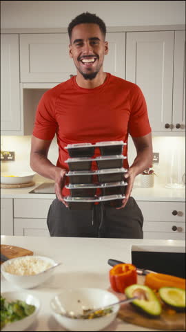 Vertical Video Portrait Of Man In Kitchen Wearing Fitness Clothing Making Batch Of Healthy Meals In Advance