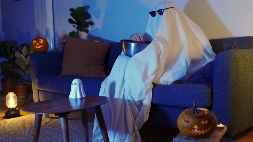 ghost with sunglasses and popcorn with pumpkins scared at halloween tv movie