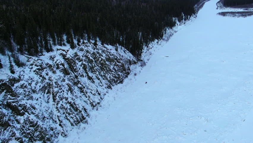 Aerial Tilt Up Beautiful Shot Snow Covered Rock Formations Under Cloudy Sky - Calico Bluff, Alaska