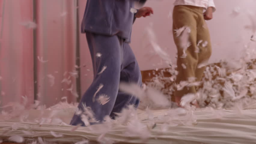 Kids in Cozy Pajamas Having a Pillow Fight - Feathers Filling the Air, Creating a Lively and Playful Atmosphere, Smiling and Expressing Sheer Joy in a Home Setting