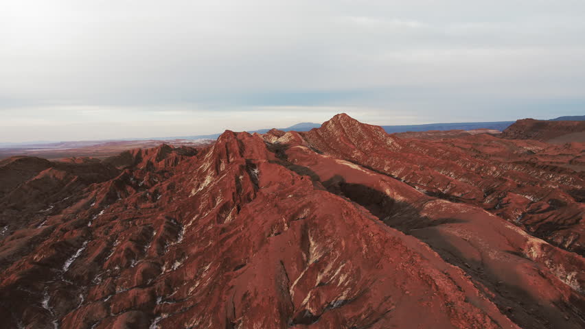 Aerial Panning Scenic Shot Of Natural Rock Formations In Tranquil Desert Under Cloudy Sky - Atacama Desert, Chile
