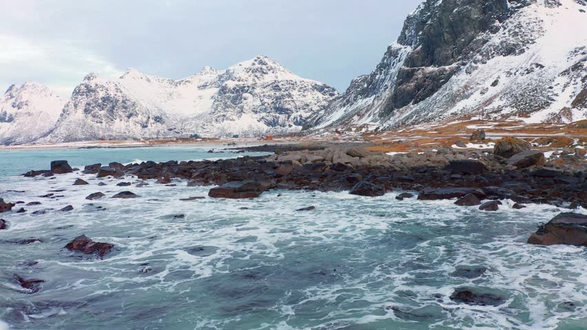 4k drone flight moving to the side footage (Ultra High Definition) of spring view of Lofoten Islands. Amazing morning scene of Snowy mountain range. Evening seascape of Norwegian sea.