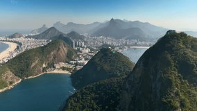Breathtaking aerial footage of Rio de Janeiro’s Sugarloaf Mountain with a cable car ascending, set against the cityscape and pristine beaches, captured in stunning clarity during midday. - Powered by Shutterstock - Get 15% off with code: PIKWIZARD15