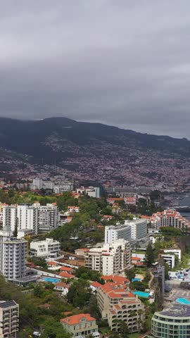Funchal City on Cloudy Day. Hotels and Atlantic Ocean. Madeira, Portugal. Aerial Drone Shot. Orbiting. Vertical Video