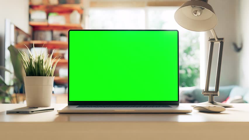 A laptop with a green screen sits on a table in a bright cozy home office. Set of 5 scenes. The film includes a tracking layer