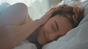 Portrait beautiful girl waking up in morning. Sleepy woman opening eyes looking camera in bedroom. Smiling curly model sleeping on cozy pillow dreaming on peaceful weekend. Lifestyle beauty concept - Powered by Shutterstock - Get 15% off with code: PIKWIZARD15