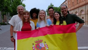 Diverse group of young people smiling at the camera while holding spanish flag outdoors. International community from different nationalities showing unity - Powered by Shutterstock - Get 15% off with code: PIKWIZARD15