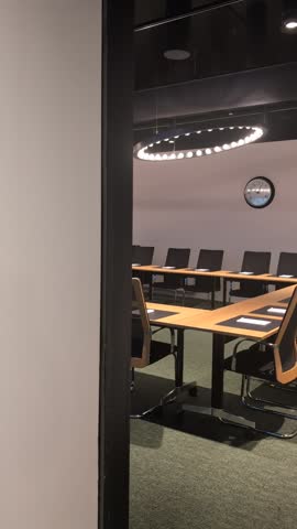 Video of a sleek, modern boardroom, empty and ready for a corporate meeting. Features minimalist design and professional office setting