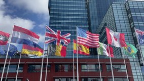 Netherlands, USA, Germany, UK, Span, Canada, Brazil, Belgium, Italy flags flying in the air in front of a office building - Powered by Shutterstock - Get 15% off with code: PIKWIZARD15
