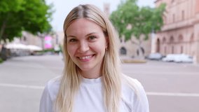 Smiling portrait of young caucasian woman looking at camera standing at city street. Joyful millennial girl feeling positive, closeup outdoor headshot. Happy people - Powered by Shutterstock - Get 15% off with code: PIKWIZARD15
