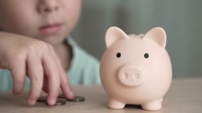 A young child is learning about financial literacy by dropping coins into a piggy bank. Concept of financial literacy from an early age - Powered by Shutterstock - Get 15% off with code: PIKWIZARD15
