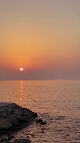 Sunset video with a boat passing by and birds are flying over to the sun