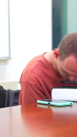 Man with cerebral palsy in the university studying with digital tablet