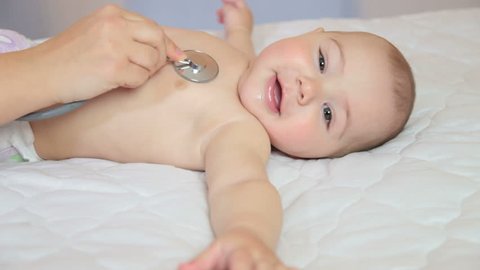 Kid doctor examing happy baby boy with stethoscope