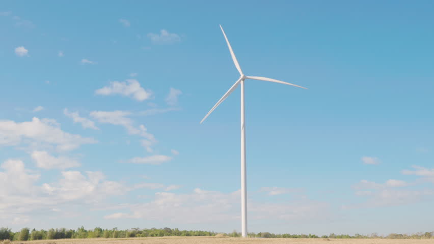Turbines on a mountain windmill farm spin in harmony with nature showcasing clean energy. Modern wind technology drives sustainable development under a blue sky.