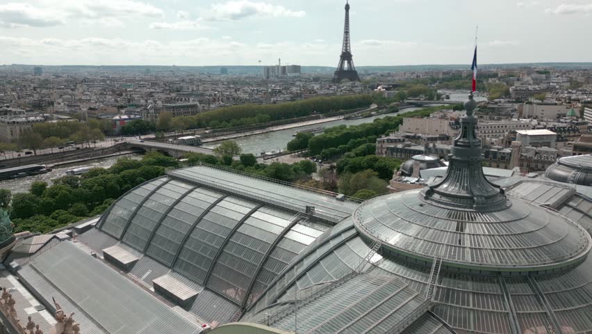 Glass roof and dome of Grand Palais or Great Palace with Tour Eiffel tower in background, Paris cityscape, France. Aerial drone panoramic view