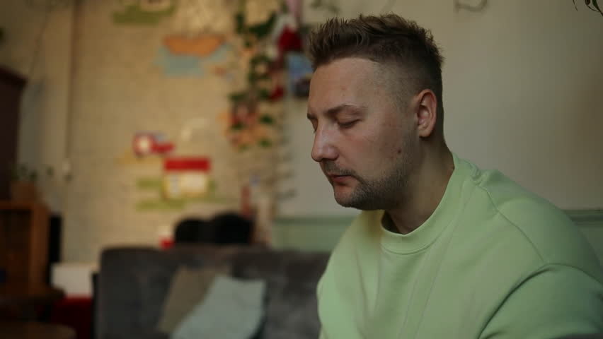 Handsome caucasian man eats food bites cake with his mouth on background of fast food restaurant. High quality 4k footage