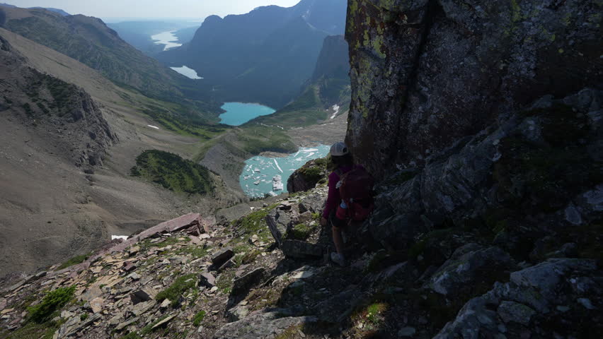 Young Female Hiker With Backpack on Scenic Lookout Above Glacial Lakes. Grinnell, Glacier National Park, Montana USA