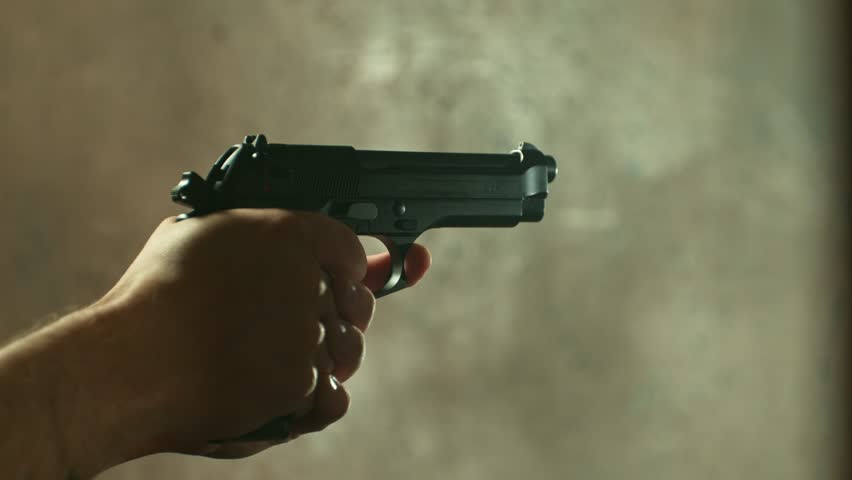 Man Shooting a Pistol on Dark Background . Super Slow Motion Filmed on High Speed Cinematic Camera at 1000 fps