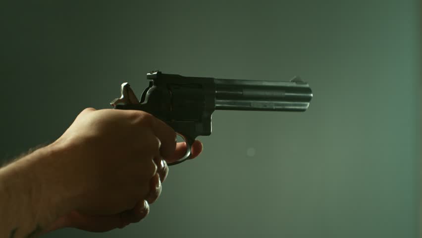 Man Shooting a Pistol on Dark Background . Super Slow Motion Filmed on High Speed Cinematic Camera at 1000 fps