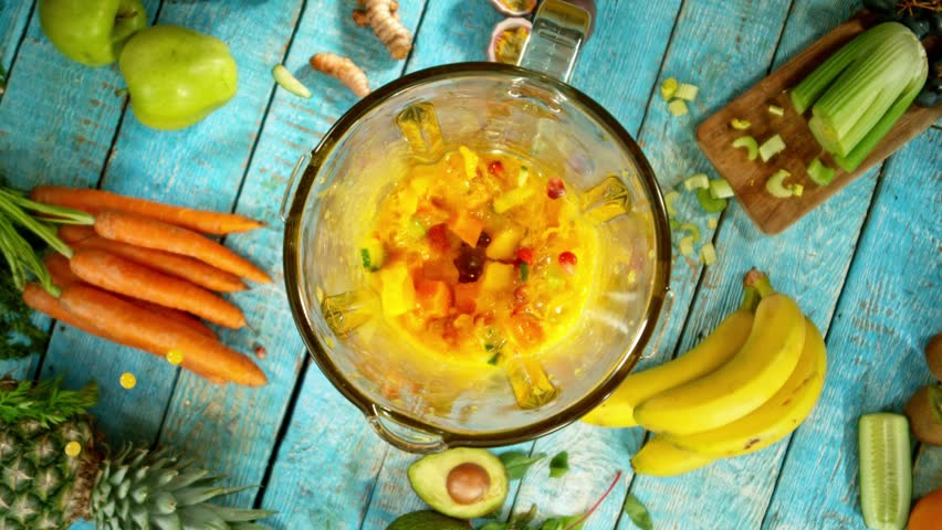 Super slow motion of mixing pieces of fruit and vegetables in blender, camera movement, top shot. Filmed on high speed cinema camera, 1000 fps.