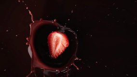 Delicious strawberry falling into chocolate, view from top, super-slow motion, drops flying to sides. Dark chocolate and red berry, cooking tasty sweet dessert for healthy nutrition, organic fruits - Powered by Shutterstock - Get 15% off with code: PIKWIZARD15