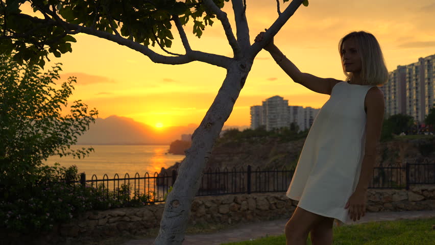 a woman is enjoying sunset