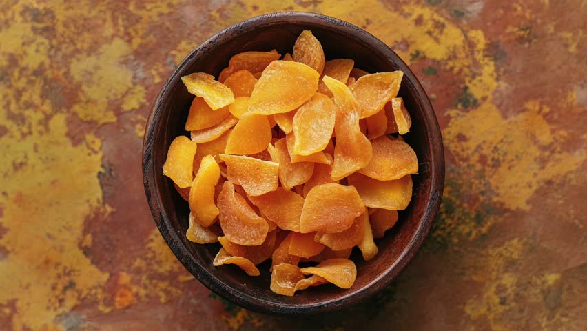 Top View Of Dried Mango Slices In Wooden Bowl
